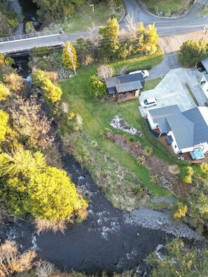 An aerial view of a residential area with a house, a swimming pool, and a bridge. - Two Rivers Boutique Lodge Ohakune (Ohakune)