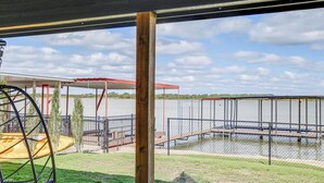 A covered outdoor area with a swing set, a fenced dock, and a view of a lake. - Lakefront Home w/ Dock & Patio in San Angelo! (San Angelo)