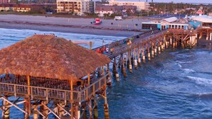A pier with a thatched-roof structure, extending into the water.