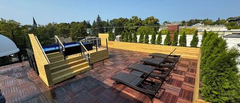 Terraza en la azotea con mesa de billar, sillas de descanso y zona de barbacoa.