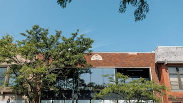 Stunning building with a brick facade and large windows, featuring a prominent sign above the entrance.