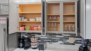 A kitchen with open cabinets, a coffee maker, a toaster, and a blender on the counter. - Tranquil 3-bedroom house with a massage chair  (Springfield)