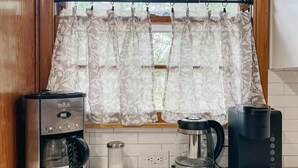 A kitchen with a coffee maker, a kettle, and a coffee machine on the counter. - The Gem - Spacious 3/2 House near ACU (Abilene)