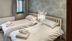 A room with two single beds, each with a white duvet and rolled towels. - Cooper Cottage - UK47544 (Potto, near Northallerton)