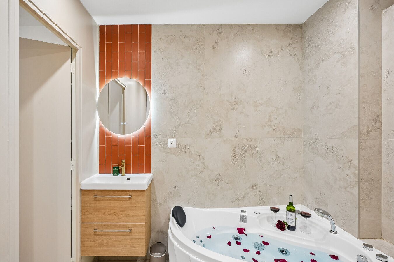 A bathroom with a bathtub, a mirror, a sink, and a wooden cabinet.