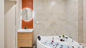 Ein Badezimmer mit einer Badewanne, einem Spiegel, einem Waschbecken und einem Holzschrank.