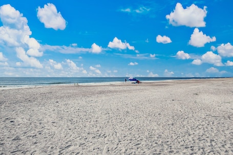 Una playa cerca, sombrillas, toallas de playa, surf