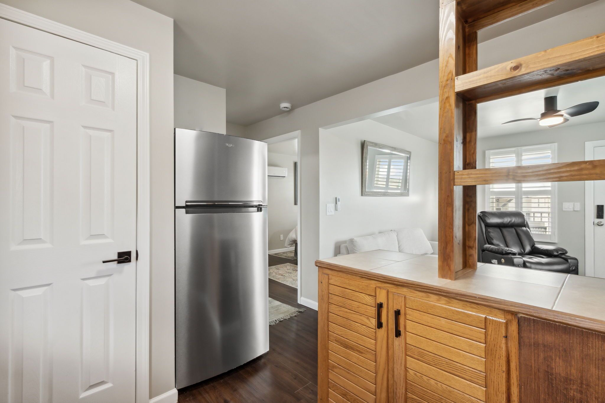 Una cocina moderna con un refrigerador de acero inoxidable, armarios de madera y un ventilador de techo.
