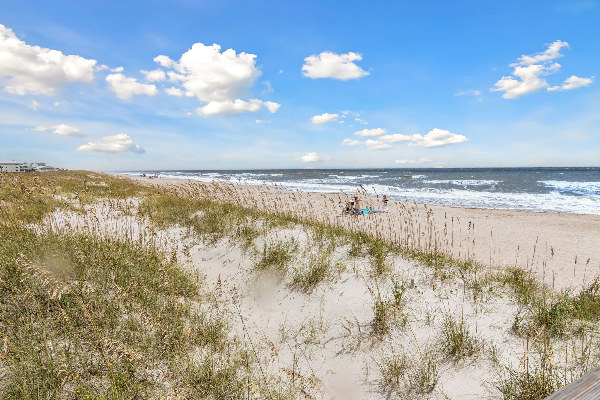 A beach with dunes and a clear sky.