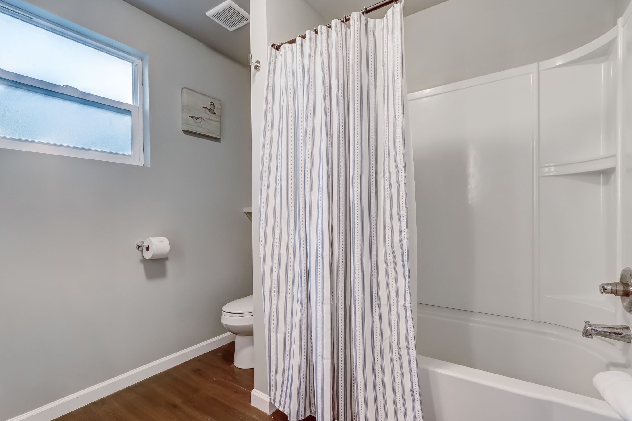 Un baño con bañera, inodoro y ventana.