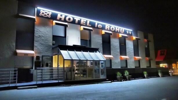 A hotel with a modern facade, a prominent sign reading "HOTEL le ROHU", and a glass entrance. - Hôtel Le Rohu (Sene)