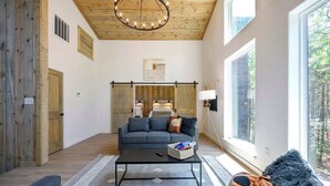 A spacious living room with a large window, a ceiling fan, and a sofa.