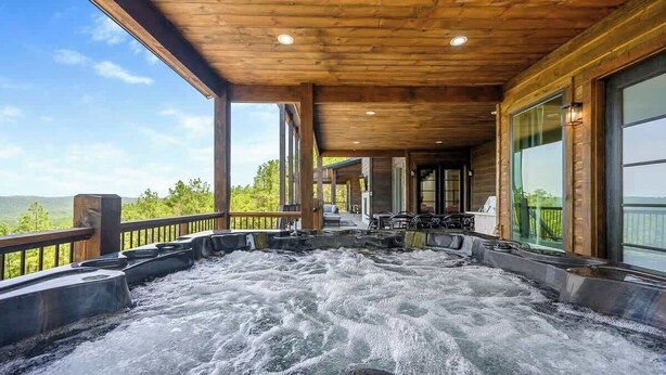 A hot tub area with a wooden ceiling and large windows.