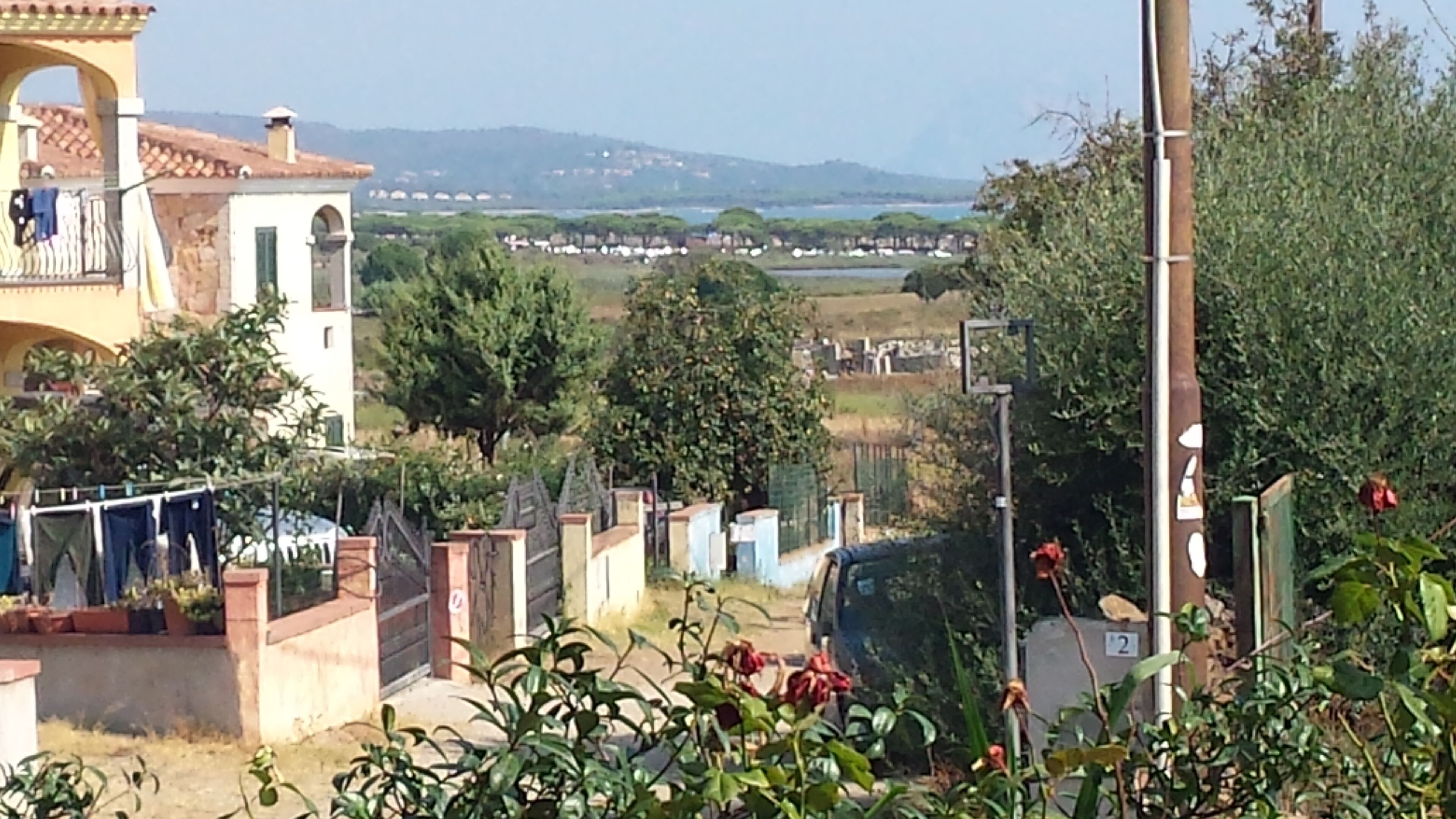 A residential area with a view of distant houses and a body of water.