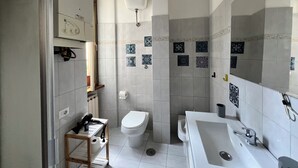 A modern bathroom with a toilet, sink, and shower.
