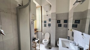 A modern bathroom with a toilet, sink, and shower area.