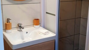Une salle de bain avec un lavabo blanc, un meuble en bois et un miroir.