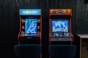 Two arcade machines, one with a racing game and the other with a fighting game, against a dark textured wall. - LakeFront with Pool! HotTub! Game Room! Sleeps 20+

 (Hot Springs)