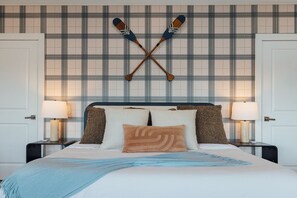 A hotel room with a bed, two nightstands, a headboard, and a wall with a plaid pattern. - LakeFront with Pool! HotTub! Game Room! Sleeps 20+

 (Hot Springs)