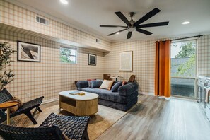 Sala de estar com sofá, mesa de centro e ventilador de teto.