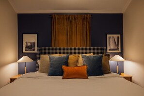 A bed with multiple pillows, a headboard with a plaid pattern, and two bedside lamps. - LakeFront with Pool! HotTub! Game Room! Sleeps 20+

 (Hot Springs)