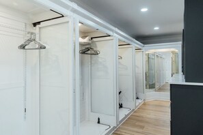 A corridor with white lockers and a wooden floor, leading to a room with a mirror and a black panel. - LakeFront with Pool! HotTub! Game Room! Sleeps 20+

 (Hot Springs)