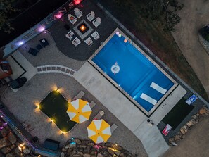 A rooftop pool area with lounge chairs, a fire pit, and umbrellas. - LakeFront with Pool! HotTub! Game Room! Sleeps 20+

 (Hot Springs)