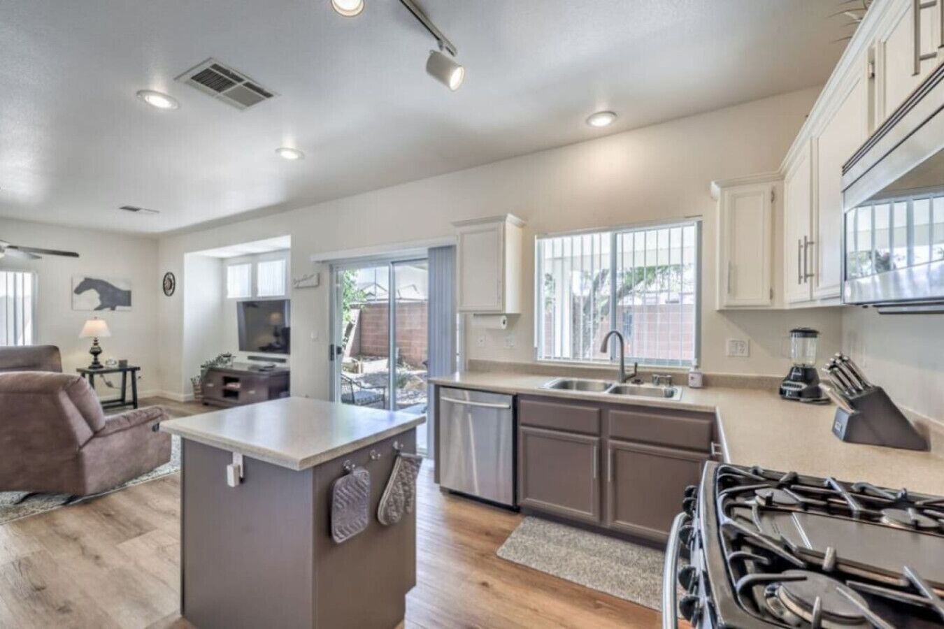 A modern kitchen with a central island, a stove, and a sink.
