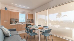 A modern kitchen with wooden cabinets and a dining area with a table and chairs.