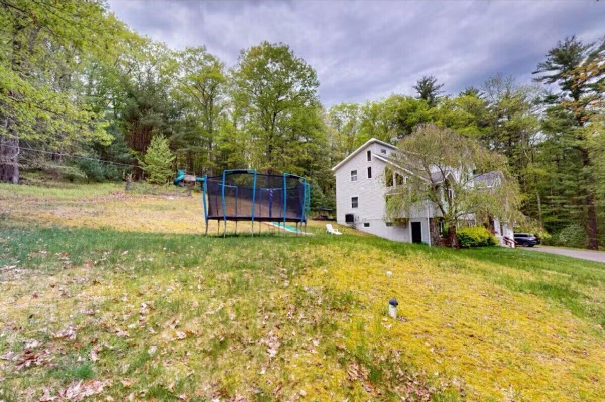 A house with a fenced yard and a trampoline.