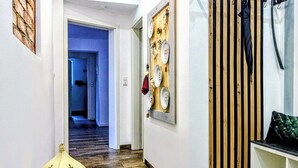 A hallway with wooden flooring, a wall-mounted rack, and a lantern.