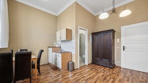 A compact kitchen with a dining area, a dark wooden wardrobe, and a white door. - Gorgeous apartment in Anklam (Anklam)