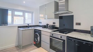 Una cocina moderna con lavadora, horno y lavavajillas integrados.