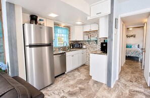A modern kitchen with a stainless steel refrigerator, a microwave, and a coffee maker.