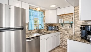 A modern kitchen with a stainless steel refrigerator, a microwave, and a coffee maker.