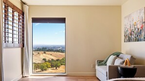 A room with a large sliding glass door leading to a scenic view of a hilly landscape. - Large Cozy Estate w/ VIEWS! 5 Min to Downtown (Paso Robles)
