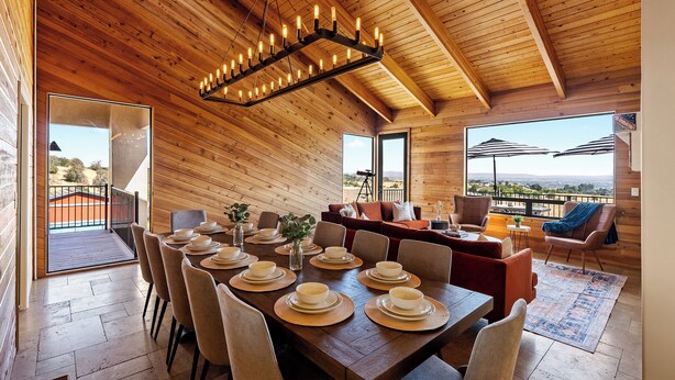A wooden interior with a dining area set for a meal, a sofa, and a balcony with a view. - Large Cozy Estate w/ VIEWS! 5 Min to Downtown (Paso Robles)