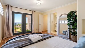 A bedroom with a bed, a balcony door, a large mirror, and a potted plant. - Large Cozy Estate w/ VIEWS! 5 Min to Downtown (Paso Robles)