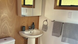 A bathroom with a toilet, sink, and mirror.