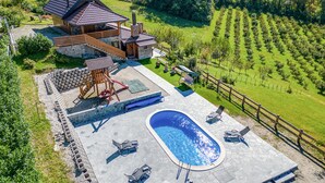Une maison avec une piscine, un espace extérieur aménagé et un jardin.