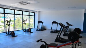A gym with treadmills, a rowing machine, and a bench press.