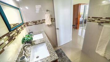 Un baño con dos lavamanos, un espejo y un perchero para toallas.