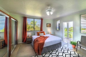 Un dormitorio con cama, ventilador de techo, ventana con cortinas, mesita de noche y planta en maceta.