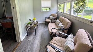 Una habitación acogedora con un conjunto de sofás, una mesita con plantas y una ventana con vistas al exterior.