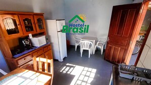 Una cocina con comedor, armarios de madera, refrigerador, microondas y pileta.