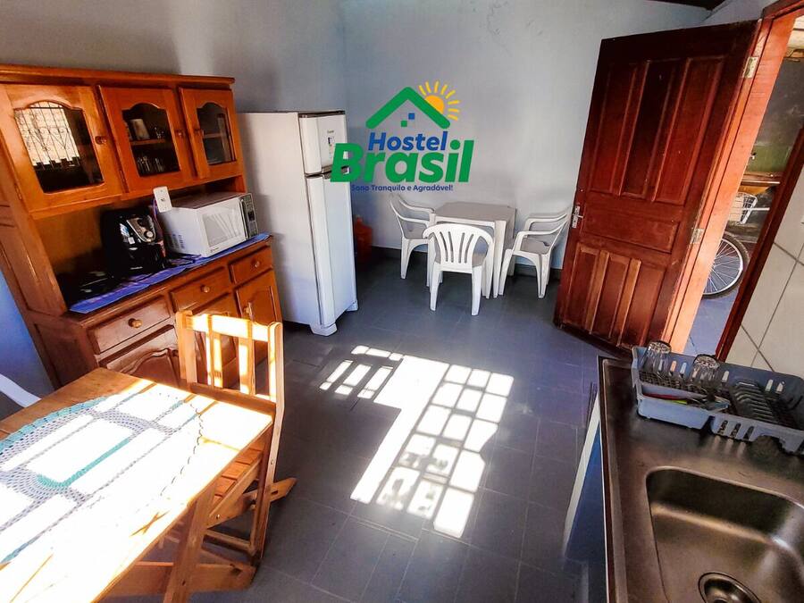 Una cocina con comedor, armarios de madera, refrigerador, microondas y pileta.