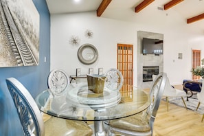 Un comedor con una mesa de vidrio, sillas y un jarrón decorativo.