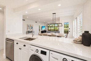 Una cocina moderna con electrodomésticos integrados, un comedor con vistas y un lavadero.