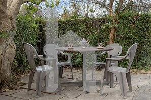 A round table with four chairs, a teapot, and two cups. - TUSCANY HOUSE is the best solution for any need, close to the center along Viale delle Piaggi and to the Cisanello hospital. A beautiful garden welcomes you in a quiet and residential area with parking space (No ZTL). The independent house is composed by (Pisa)