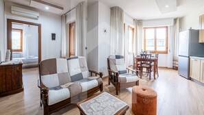 A modern living room with a sofa, armchairs, a coffee table, and a dining area with a table and chairs. - [Homiday] Elegant apartment with wooden finishes in the central area.Relax and enjoy the three bright double bedrooms equipped with air conditioning and heating. Homiday offers the perfect accommodation for those who travel for work or leisure, in the ar (Pisa)